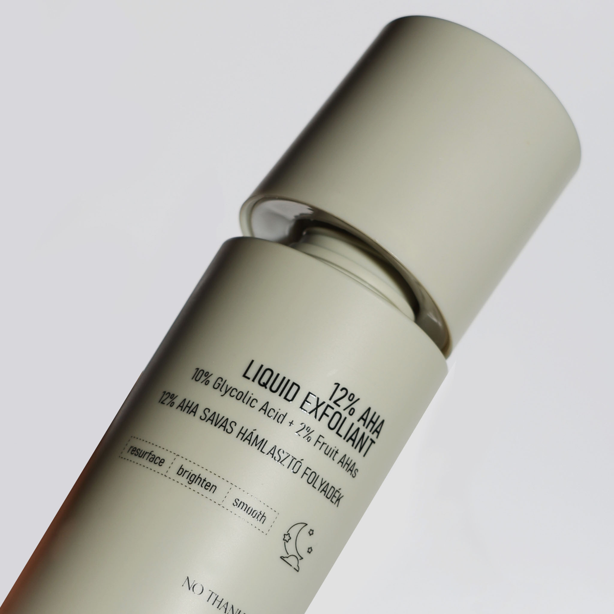 Close-up eines Nerds 12% AHA Liquid Exfoliants in beigefarbener Flasche mit aufgeklapptem Deckel, schräg fotografiert auf hellem Hintergrund.