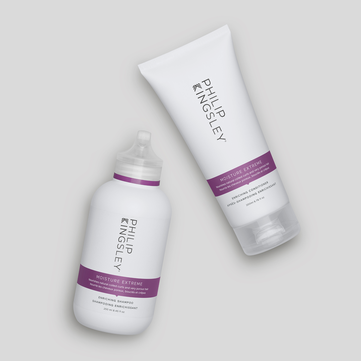 Zwei weiße Flaschen „Philip Kingsley Moisture Extreme Conditioner“ mit violetten Etiketten auf hellgrauem Hintergrund.