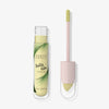 Geöffnete Tube Physicians Formula Butter Glow Corrector in Gelb mit Applikator daneben.