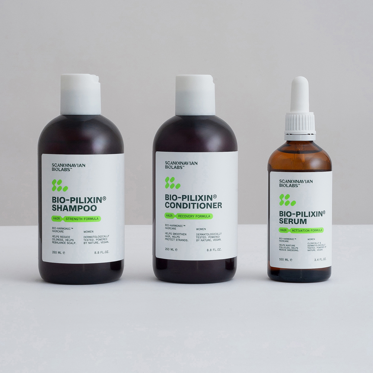 Die Bio-Pilixin® Haaraktivierungsroutine für Frauen von Scandinavian Biolabs, bestehend aus Shampoo, Spülung und Serum, wird auf einer weißen Fläche präsentiert.