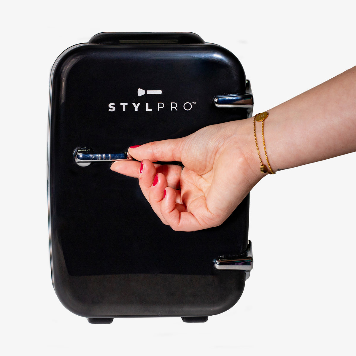Eine Hand mit roten Nägeln öffnet einen schwarzen Beauty Fridge vor weißem Hintergrund.