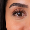Nahaufnahme eines braunen Auges mit langen Wimpern, gepflegten Augenbrauen und glatter Haut – erzielt mit „The Brow Serum“ von SWEED.