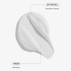 Nahaufnahme der weißen AHA Smoothing Body Lotion, die auf „Fluid Glow Texture“ und „Soft Glow“-Finish hinweisen.