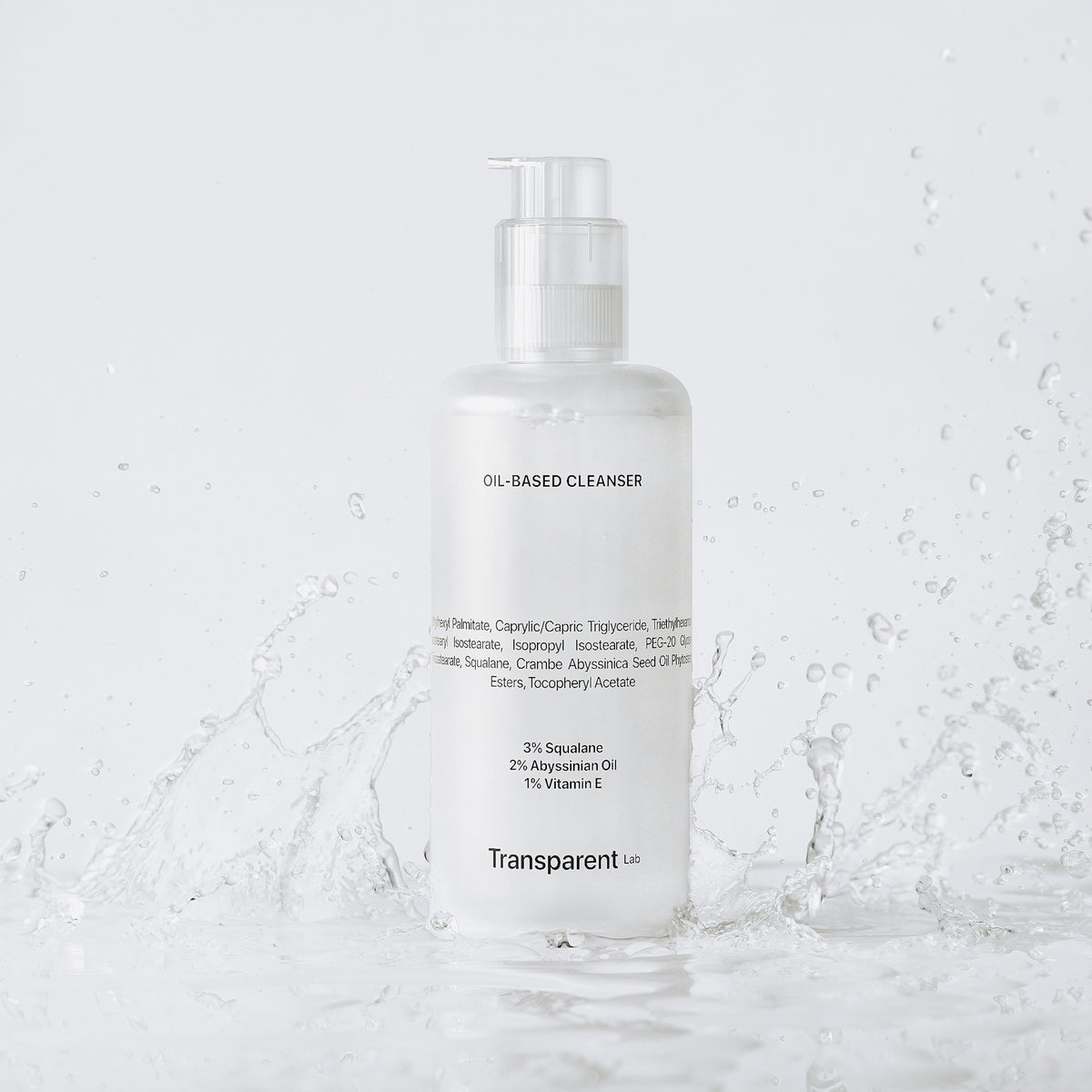 Eine Flasche des ölbasierten Reinigers des Max Hydration Bundle mit Pumpe, bespritzt mit Wasser vor einem weißen Hintergrund.