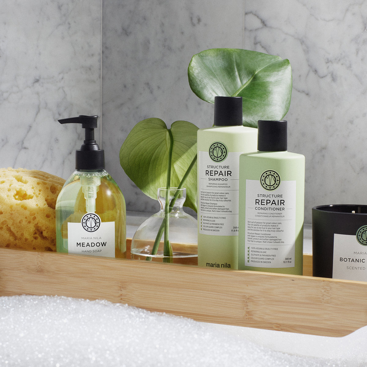 Maria nila Structure Repair Conditioner und Shampoo auf einem Badewannen-Holztablett.