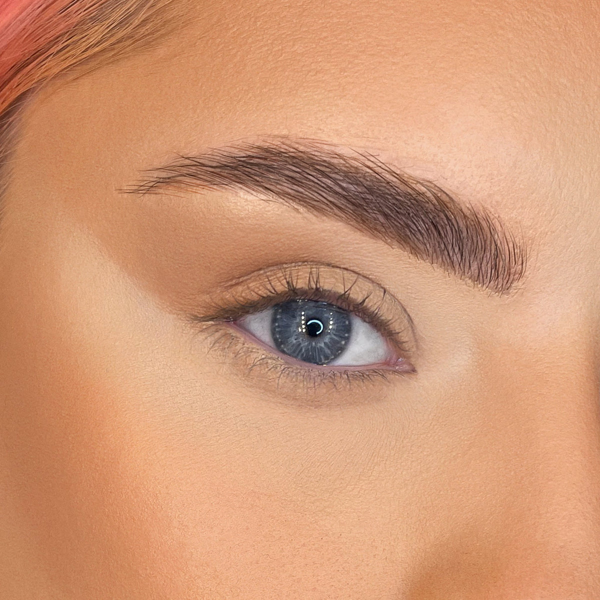 Nahaufnahme eines blauen Auges ohne Mascara und einem natürlichen Make-up-Look.