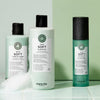 Drei Produkte der Maria Nila True Soft Reihe mit Wassertropfen und Schaum auf mintgrünem Hintergrund.