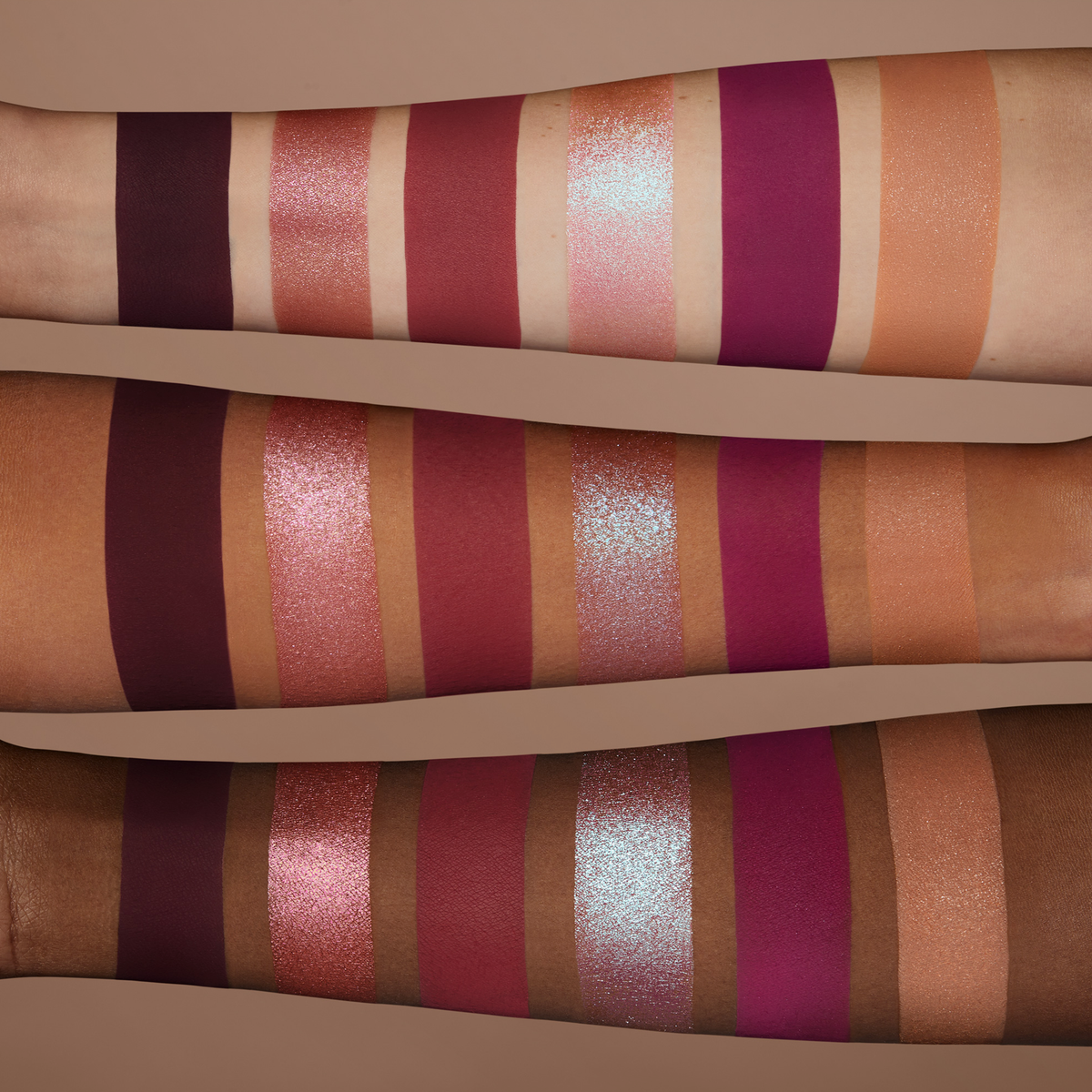 Swatches der NABLA Cutie Palette „Wild Berry“ auf drei Hauttönen – sechs schimmernde und matte Lidschatten in Beerentönen von Rosa bis Violett.