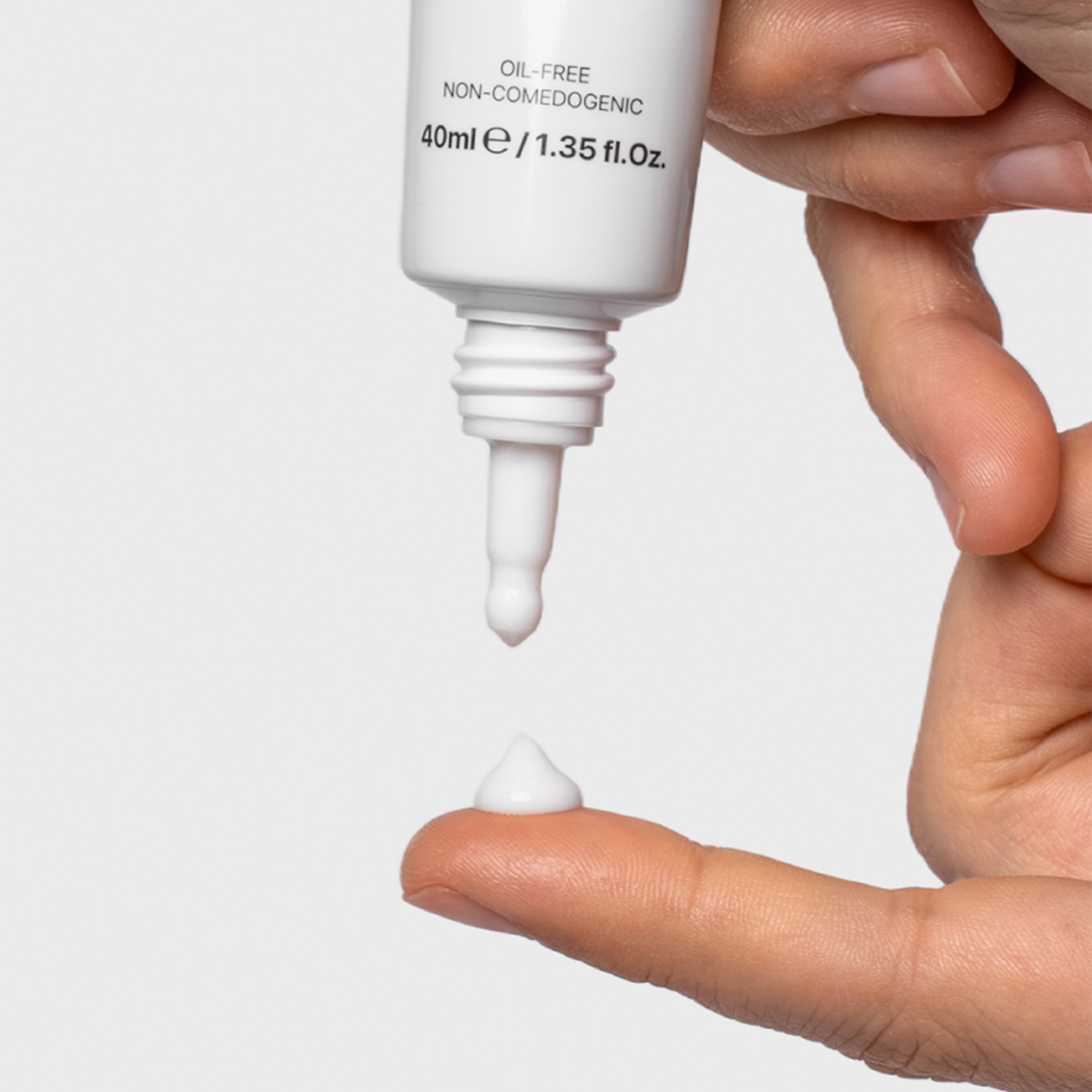 Eine Hand tropft vor weißem Hintergrund etwas Adapzit® auf einen Zeigefinger.