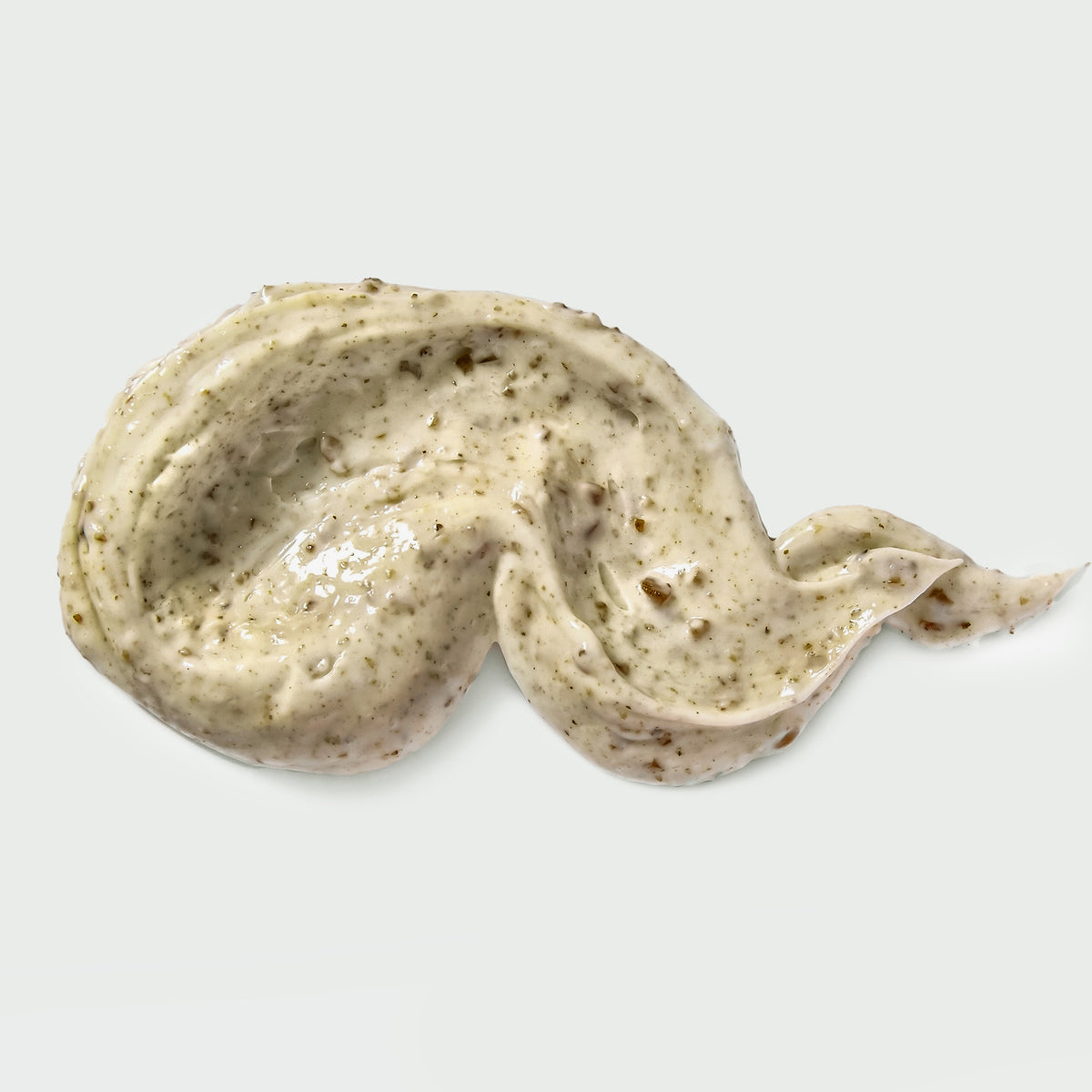 Beigefarbene Gesichtsreinigungscreme mit feinen Peelingpartikeln, in einer geschwungenen Textur auf weißem Hintergrund aufgetragen.