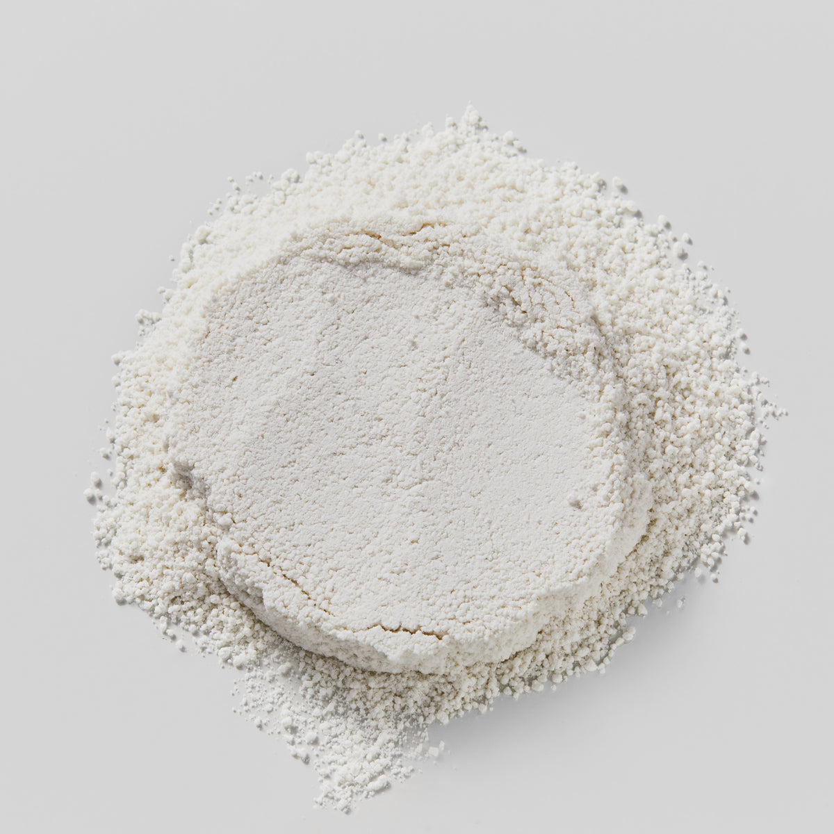 Ein Haufen Rice Enzyme Brightening Cleansing Powder erscheint als feines weißes Pulver auf einem schlichten weißen Hintergrund.