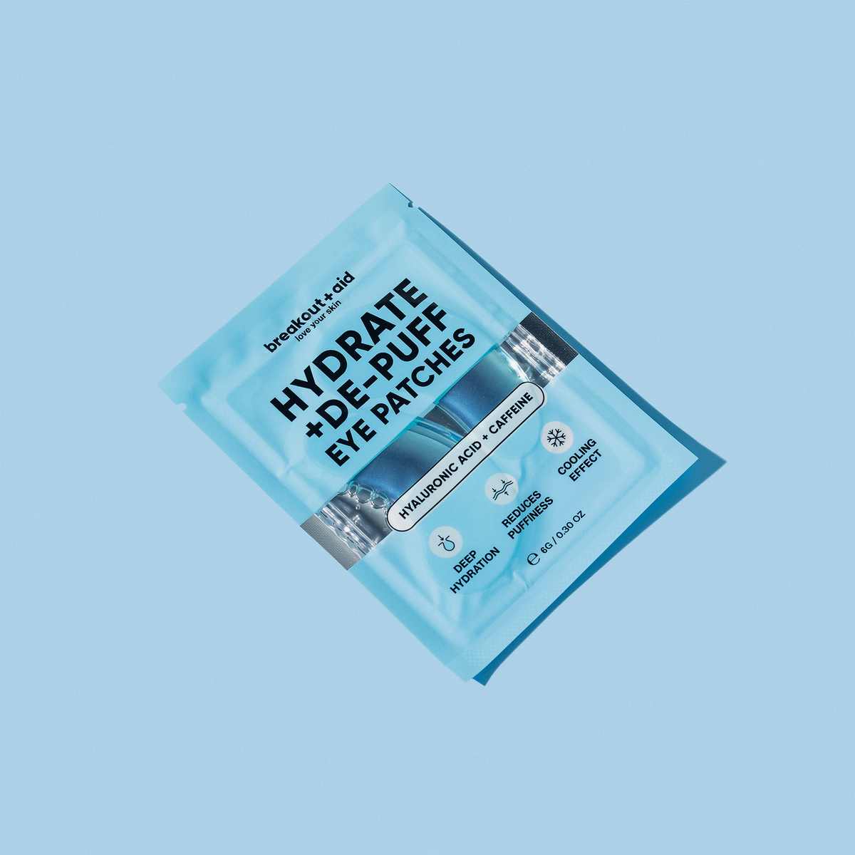 Eine Einwegpackung breakout+aid Hydrate + De-Puff Eye Patches vor hellblauem Hintergrund.