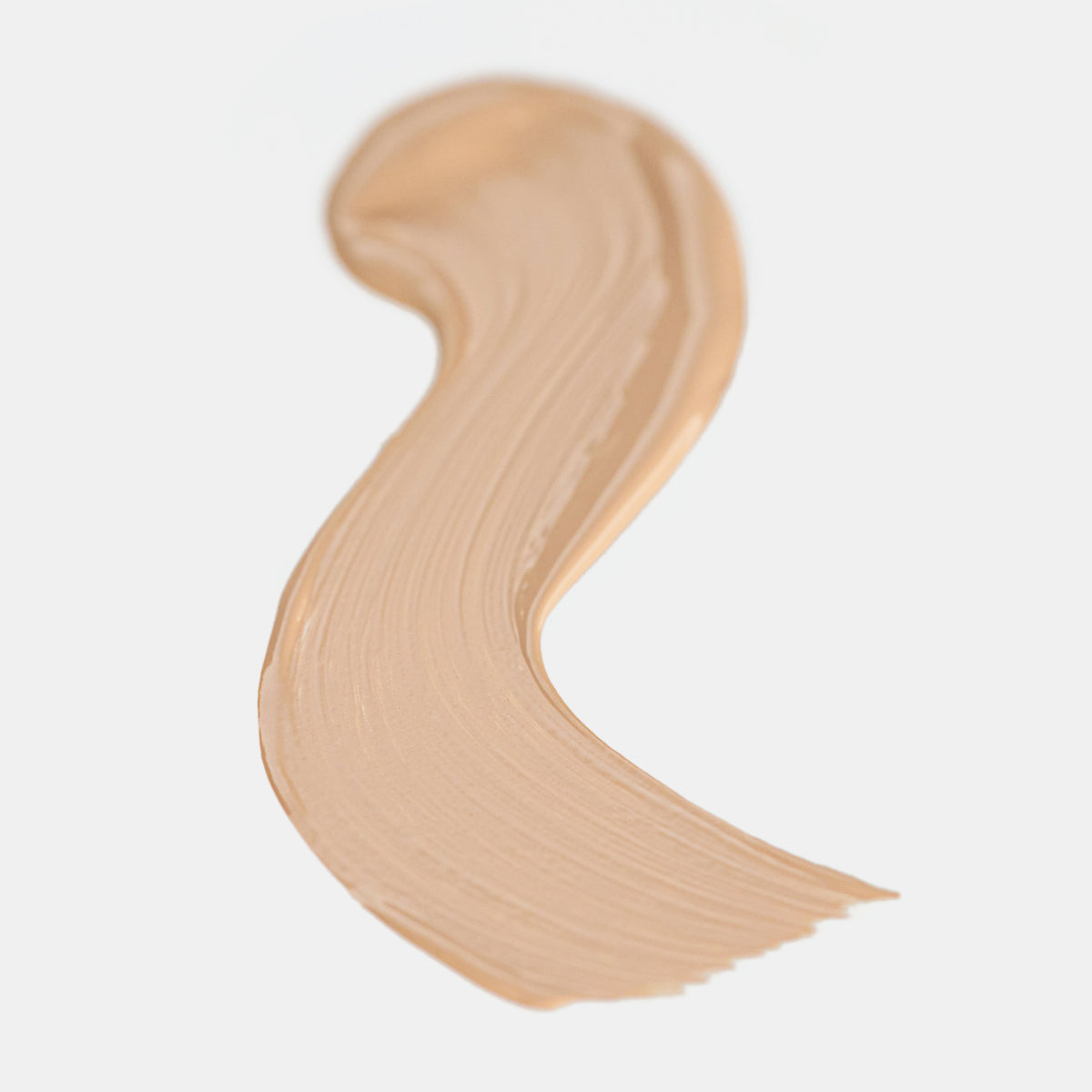 Cremiger Farbstreifen des Catrice Instant Bright Serum Concealers in der Farbe 002N (neutrales Beige) auf heller Oberfläche.