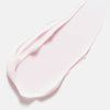 Ein Abstrich der zartrosa Creme von Color Wow Dreaming Treatment auf weißem Hintergrund.