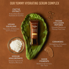 Tube Yummy Skin Serum Tint liegt auf einem Aloe Vera Blatt; umringt von Infos zu Inhaltsstoffen.