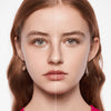 Geteiltes Gesicht einer jungen Frau mit hellem Hautton zeigt links natürliche Haut und rechts perfektioniertes Hautbild mit MAGIC FILTER Glow Booster 10 Light.