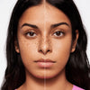 Geteiltes Gesicht einer jungen Frau mit mittlerem Hautton zeigt links natürliche Haut und rechts perfektioniertes Hautbild mit MAGIC FILTER Glow Booster 20 Medium.