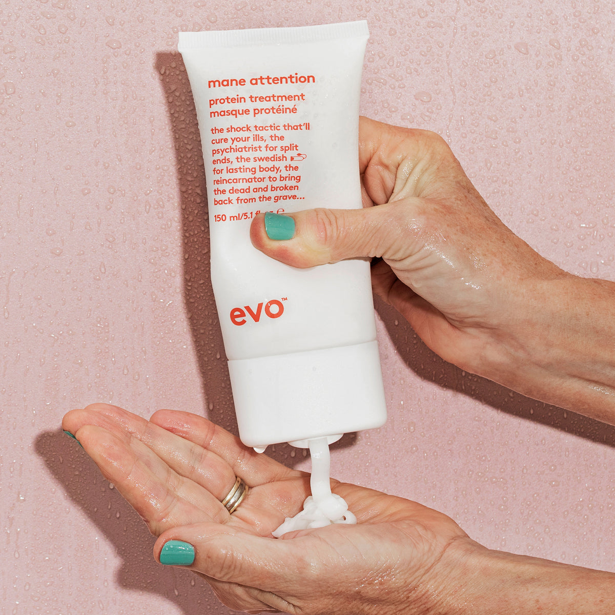 Person drückt Mane Attention Protein Treatment auf ihre Hand vor nassem Hintergrund.