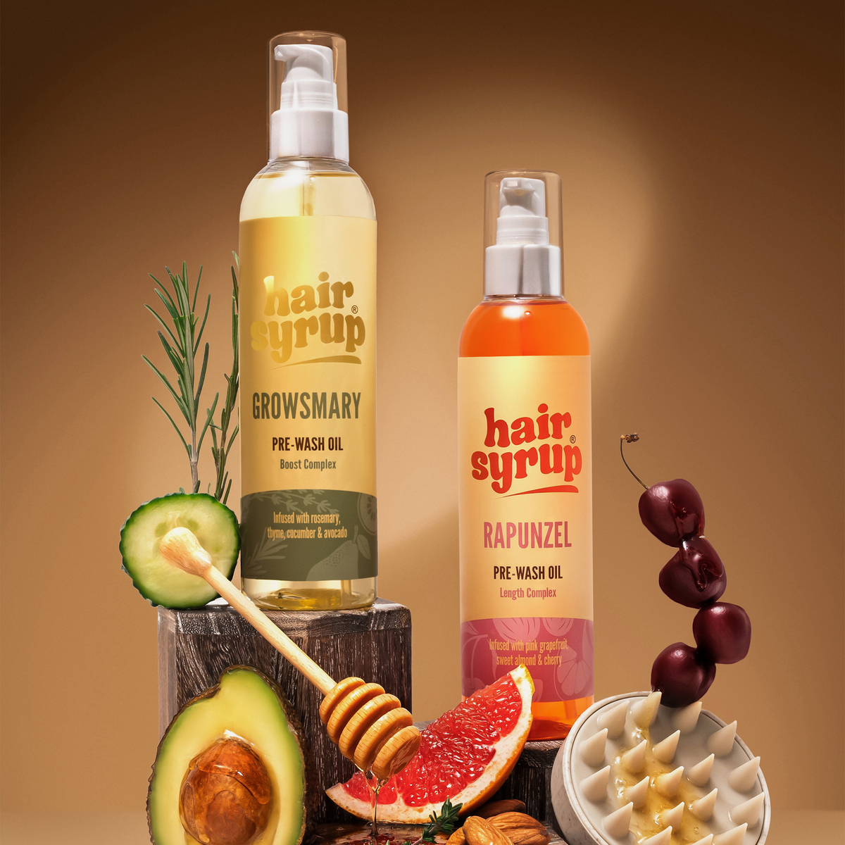 Zwei Hair Syrup Pre-Wash-Ölflaschen mit Avocado, Honig, Grapefruit, Nüssen und Kirschen auf braunem Hintergrund.