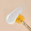 Eine Pipette mit Vitamin C Glow Serum und ein Klecks weißer Creme vermischen sich auf einem beigen Hintergrund.