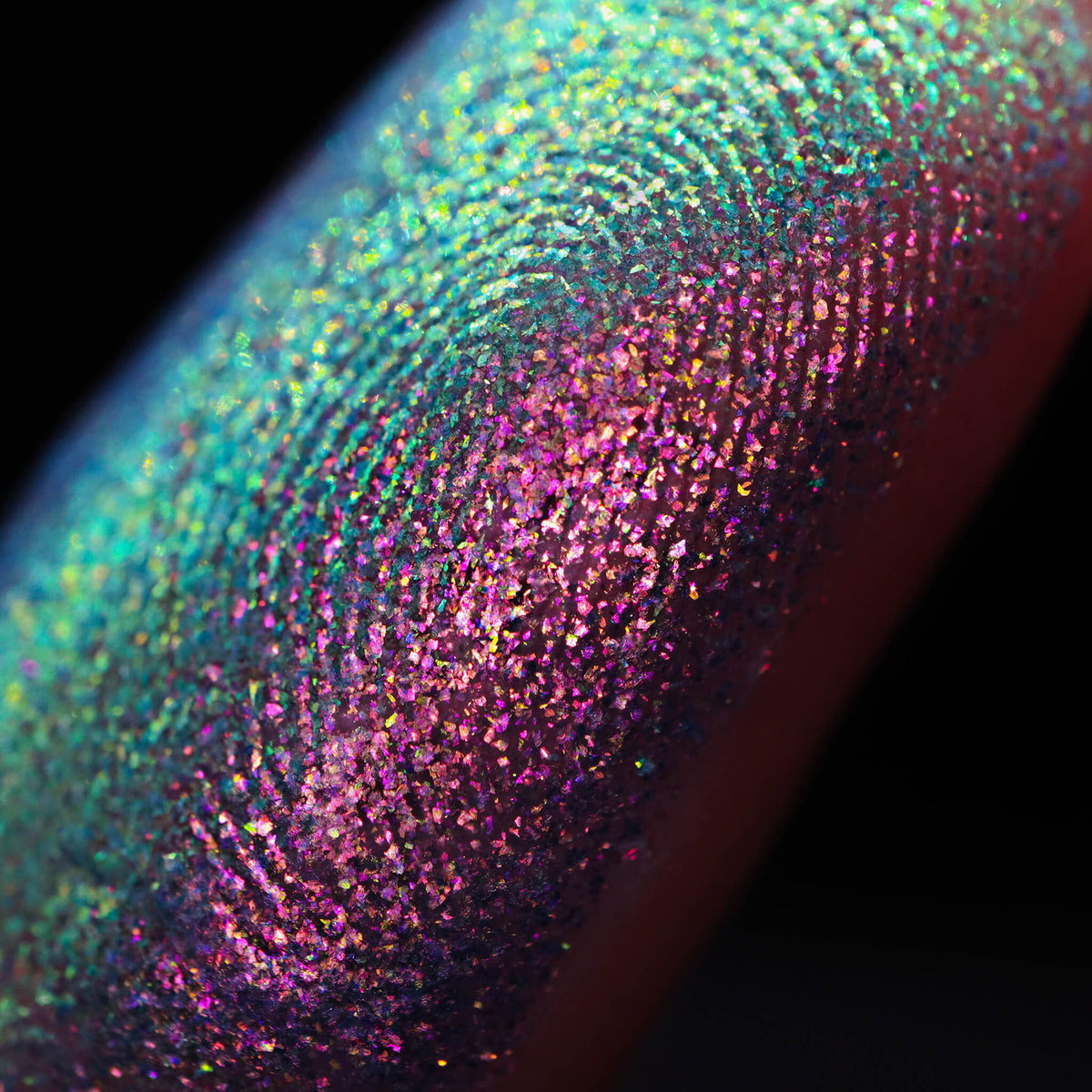 Nahaufnahme einer Fingerspitze, die in den Opal Moonstone Loose Multichrome Eyeshadow Sleepy Head getaucht wurde und blau-violett glitzert.
