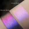 Zwei schimmernde Muster des Opal Multichrome Loose Eyeshadow Nightfall mit unterschiedlichen Grundierungen; eins mit der Black Base (pink-lila), eins mit der Fix Potion (rosa-violett).