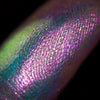Nahaufnahme einer Fingerspitze, die in den Opal Multichrome Loose Eyeshadow Rockabye Baby getaucht wurde und grün-blau und rosa-lila glitzert.