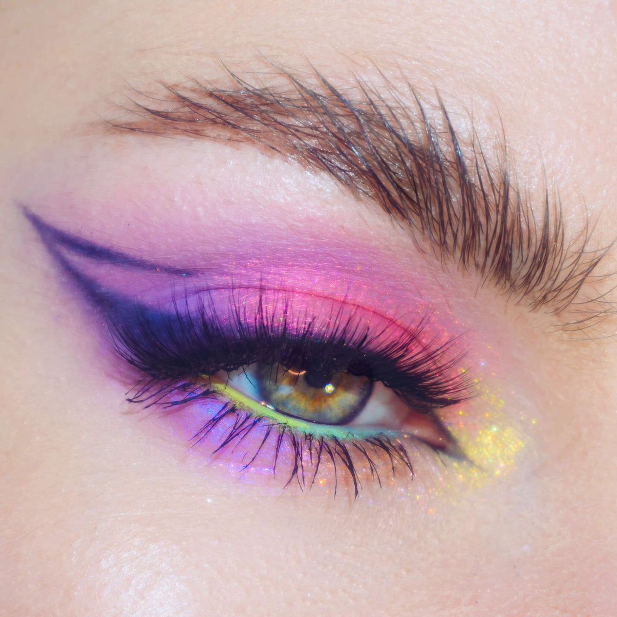 Nahaufnahme eines Auges mit dramatischem Eyeliner und pink schimmerndem Pastel Duochromes Loose Eyeshadow in Blossom.