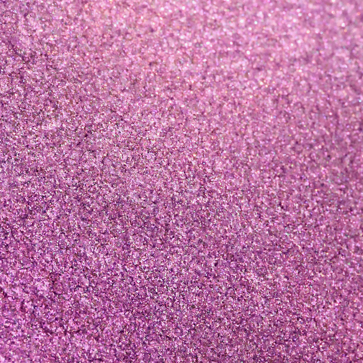 Nahaufnahme der Textur des Pastel Duochromes Loose Eyeshadow Dolly; ein rosa-violett schimmerndes Pigment.