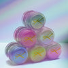 Sechs Tiegel des Pastel Duochromes Loose Eyeshadow gestapelt wie einer Pyramide vor weißem Hintergrund.