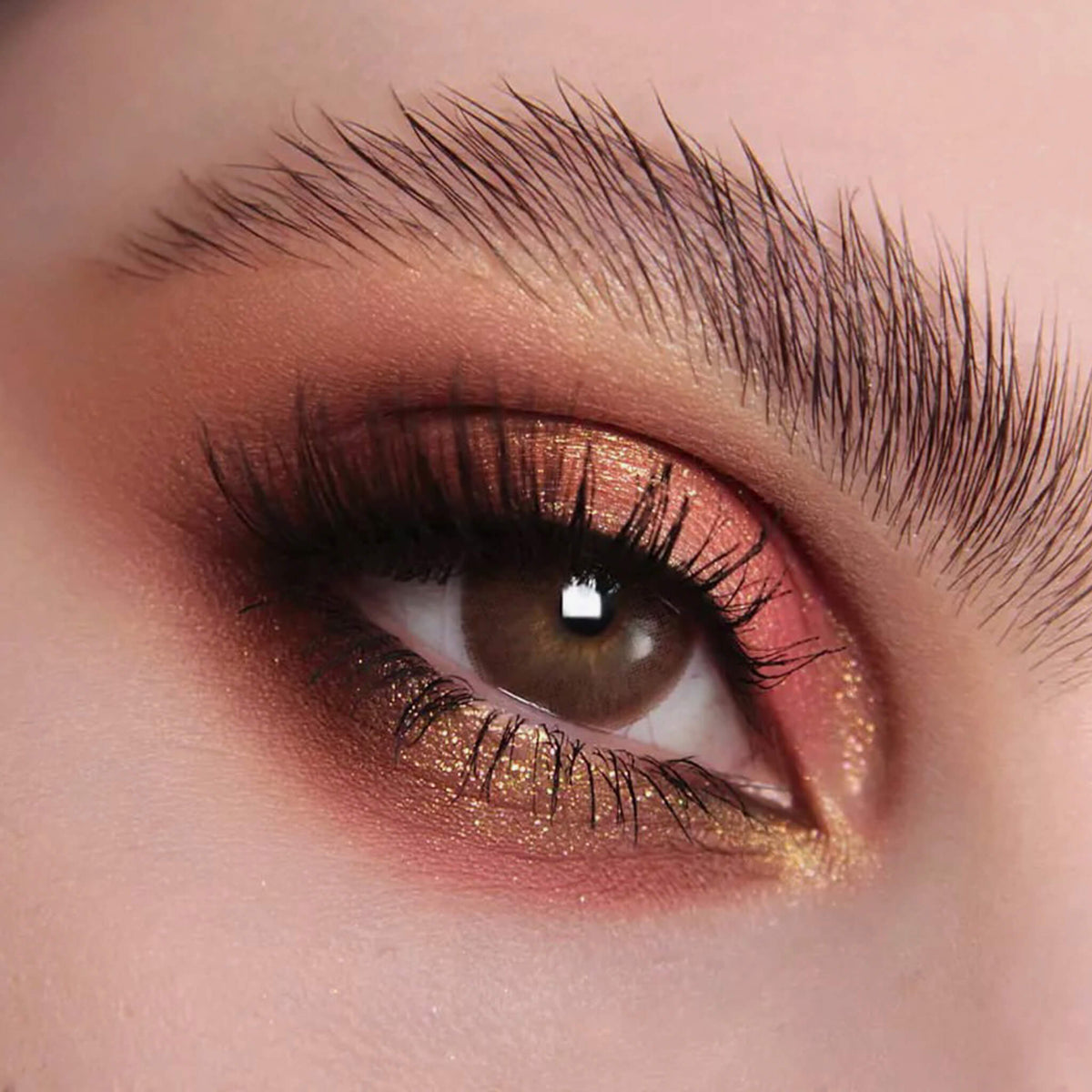 Nahaufnahme eines Auges mit dramatischem Eyeliner und orange-gold schimmerndem Pastel Duochromes Loose Eyeshadow in Sherbet.