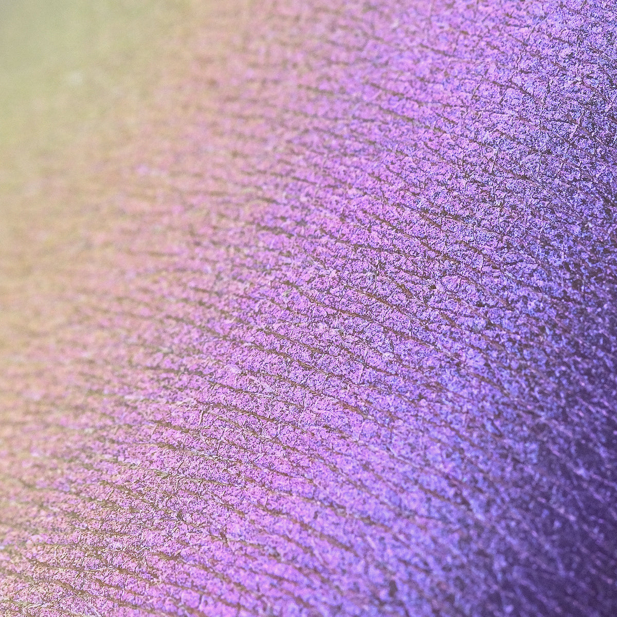 Nahaufnahme der Textur der Pressed Opal Multichrome Eyeshadow Nightfall, die lila auf der Haut schimmert.