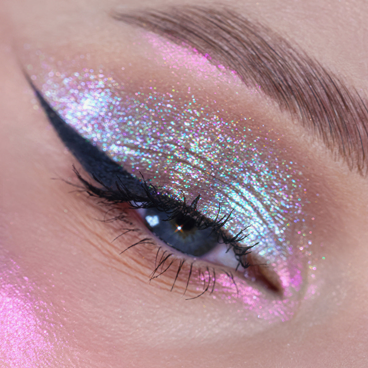 Nahaufnahme eines Auges mit dramatischem Eyeliner und bunt schimmerndem Pressed Opal Multichrome Eyeshadow in Velvet Dreams.