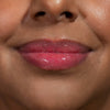 Nahaufnahme von Lippen einer Person mit mittelbraunem Teint mit pink glitzerndem Glazed Sugar Lipgloss von LH Cosmetics.