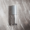 Tube Sparkl Flash liegt auf glitzerndem verstrichenen Inhalt als Hintergrund.