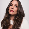 Eine Frau mit langem braunem voluminösem Haar, gestylt mit der Living Proof Full Thickening Blow-Dry Cream.