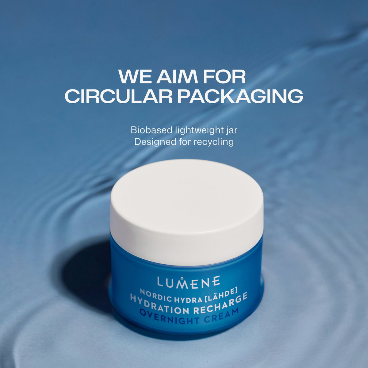 Der blaue Tiegel der Lumene Nordic Hydra [LÄHDE] Intense Hydration Night Cream steht auf einer blauen Wasseroberfläche, deren Text die recyclebare Verpackung hervorhebt.