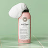 Dose maria nila Pure Volume Mousse in Rosa mit weißem Schaum auf der Spitze, vor einem grünen Hintergrund.