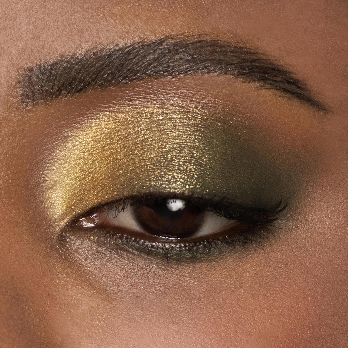 Nahaufnahme eines Auges mit goldenem und grünem Metallic-Lidschatten aus der Bare Harmony 3.0 Palette von Mesauda Beauty.