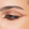 Nahaufnahme eines Auges mit schimmerndem braunem Lidschatten, geflügeltem Liner und definierten Augenbrauen, kreiert mit der Bare Harmony 3.0 Palette von Mesauda Beauty.