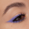 Nahaufnahme eines Auges mit kräftigem lila Lidschatten und scharfem Wing, kreiert mit NABLA Cosmetics Cupids Arrow Longwear Stylo.