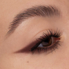 Nahaufnahme eines Auges mit langen Wimpern und scharf umrandetem braunem Lidschatten, kreiert mit NABLA Cosmetics Cupids Arrow Longwear Stylo.