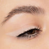 Nahaufnahme eines Auges mit beigefarbenem Lidschatten in Wing-Form und schwarzem Eyeliner auf dem oberen und unteren Wimpernkranz.
