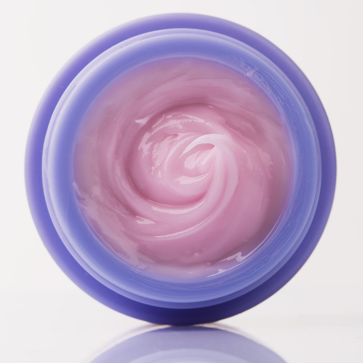 Die rosa Creme des Viper Delicious Lip Kit befindet sich in einem offenen, runden violetten Behälter, der von oben auf einem weißen Hintergrund zu sehen ist.
