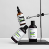 Drei Bio-Pilixin® Hair Activation Routine - Men Produkte von Scandinavian Biolabs werden mit einem Laborständer auf einer weißen Fläche präsentiert.