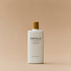 Eine weiße Flasche Madagascar Centella Air-Fit Suncream Plus mit goldenem Deckel auf beigem Hintergrund.