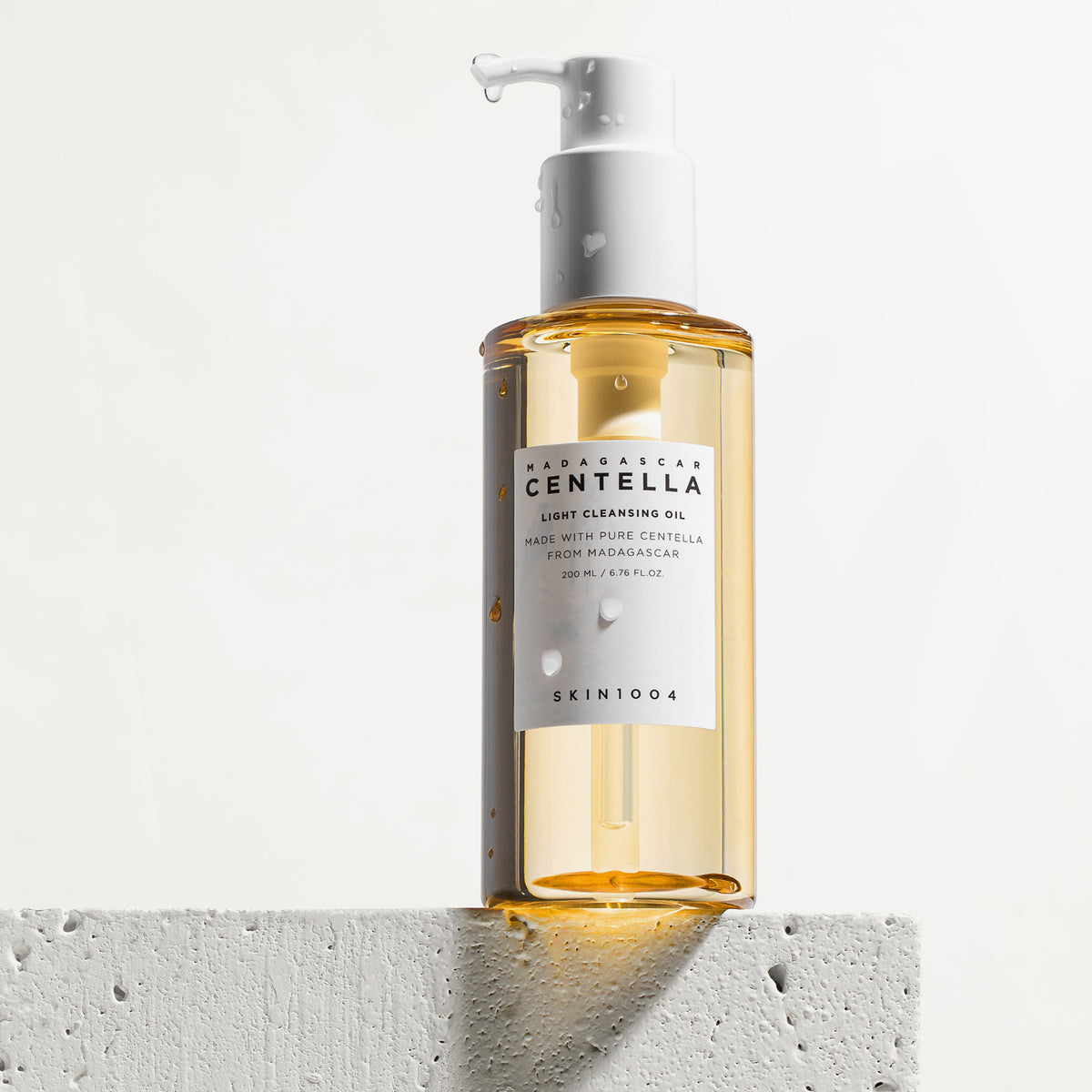 Die Flasche „Madagascar Centella Light Cleansing Oil“ steht auf einer weißen strukturierten Oberfläche.