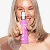 Eine Frau hält die Flasche HA LAVENDER SPRAY mit Matrixyl 3000 in die Kamera.