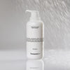 Eine weiße Flasche Hydrating Glycerin Body Cleanser mit einer Pumpe wird unter einen Wasserstrahl gehalten.