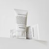 Zwei Tuben Niacinamide Glow Cream stehen auf einem hellen Sockel auf weißem Hintergrund.